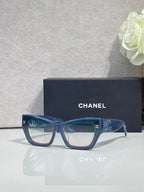 Eyeglasses with blue square frames and clear lenses, CHANEL logo on temples.