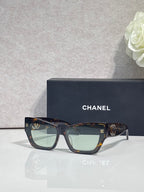 Eyeglasses pair with tortoiseshell and dark frames, CHANEL logo details on temples.