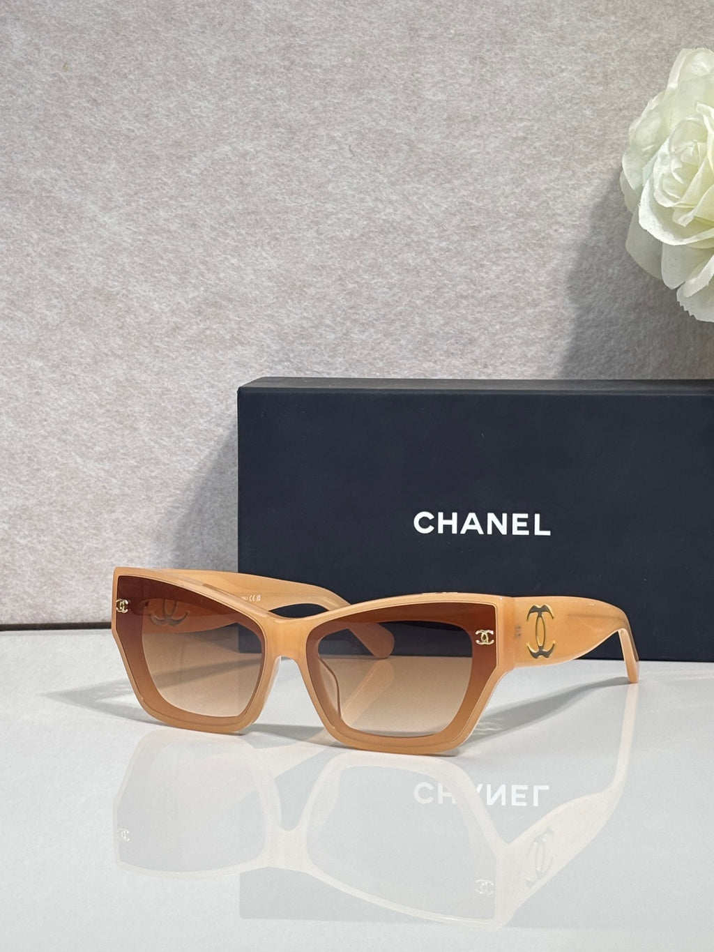 Eyeglasses with amber square frames and tinted lenses, CHANEL logo on temples.