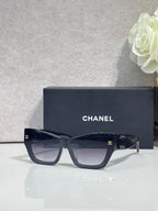 Eyeglasses with dark navy square frames and tinted lenses, CHANEL logo on temples.