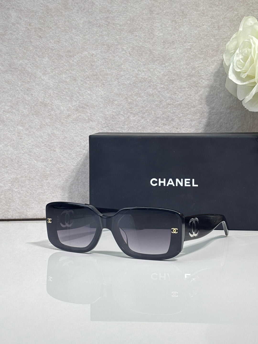 Dark navy square-frame glasses with logo hardware and tinted lenses