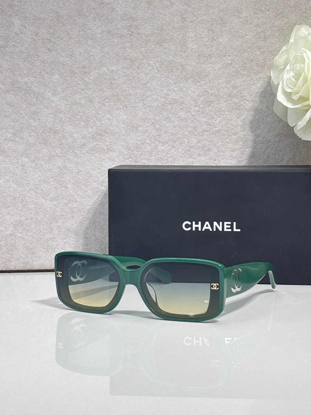 Green rectangular-frame glasses with logo hardware and tinted lenses