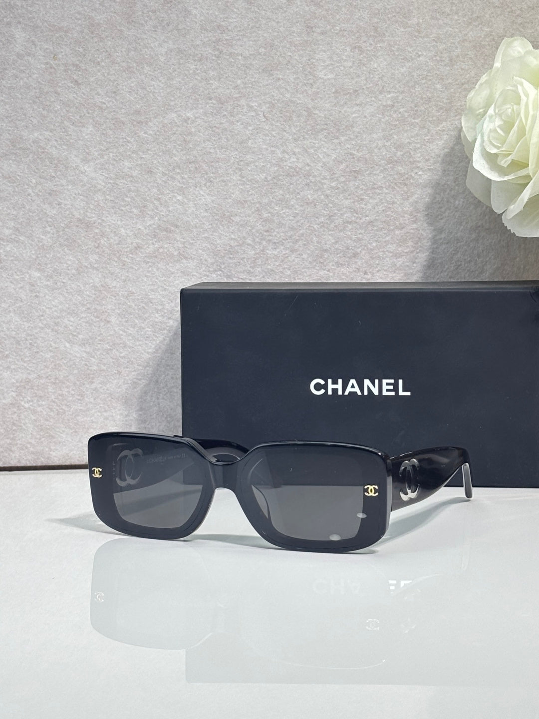Black square-frame glasses with logo temples and tinted lenses