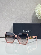Chanel sunglasses with pink square frames, dark lenses, and gold temple hardware