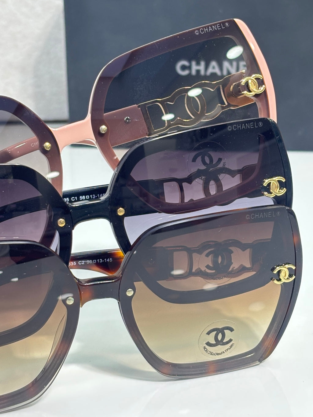 Chanel sunglasses close-up of lenses and pink frame with gold logo and hinge details