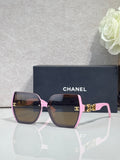 Chanel sunglasses with pink square frames, dark lenses, and gold temple details