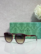 Gucci glasses with burgundy square frames, gold accents, and tinted lenses