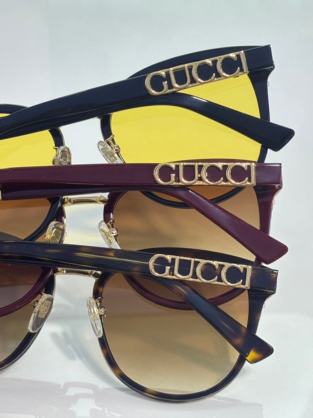 Gucci glasses with navy frames, gold logo lettering on temples, and yellow lens panels