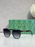 Gucci glasses with black square frames, gold accents, and dark lenses