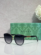 Gucci glasses with black square frames, gold accents, and dark lenses