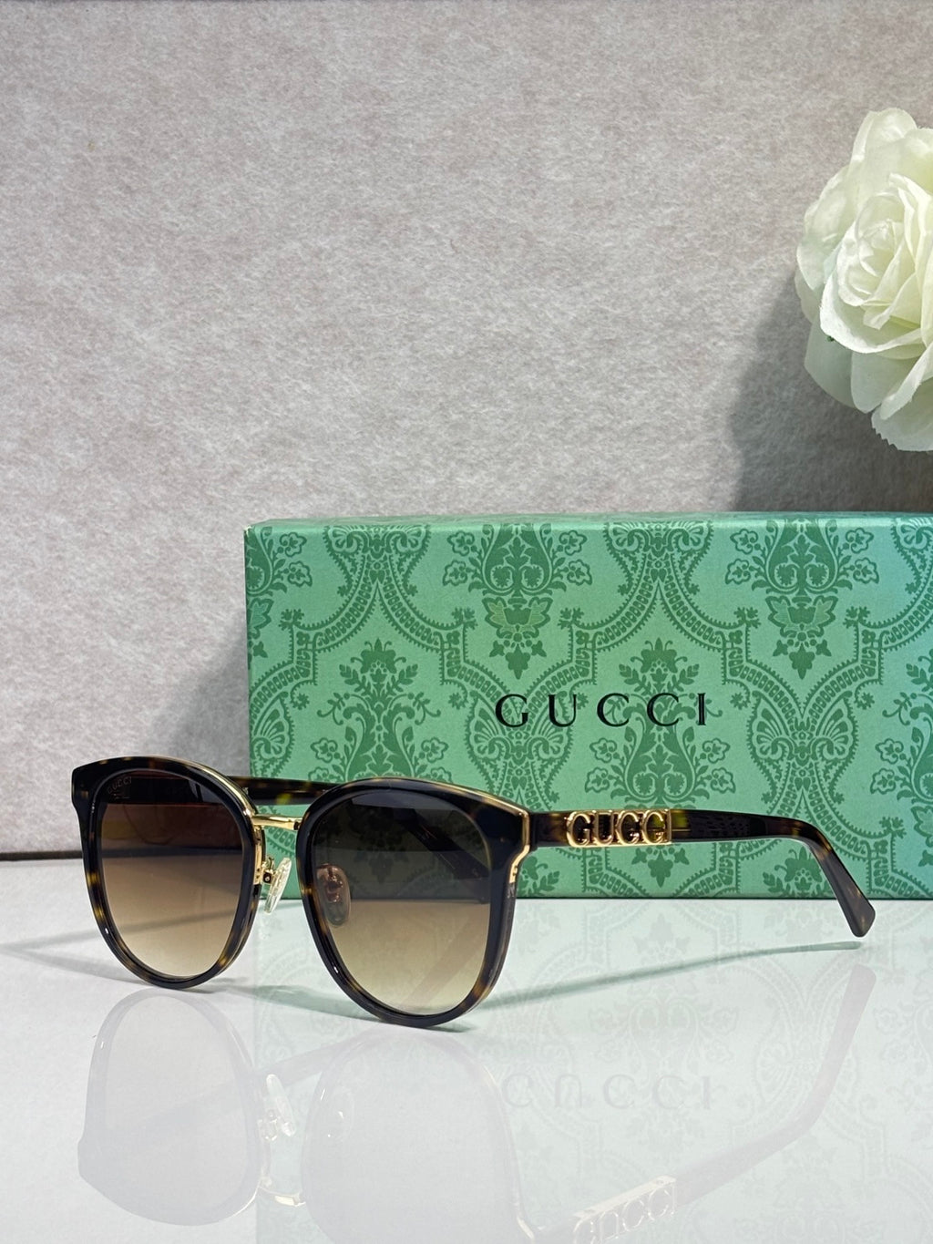 Gucci glasses with black square frames and gold detailing with tinted lenses