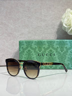 Gucci glasses with black square frames and gold detailing with tinted lenses