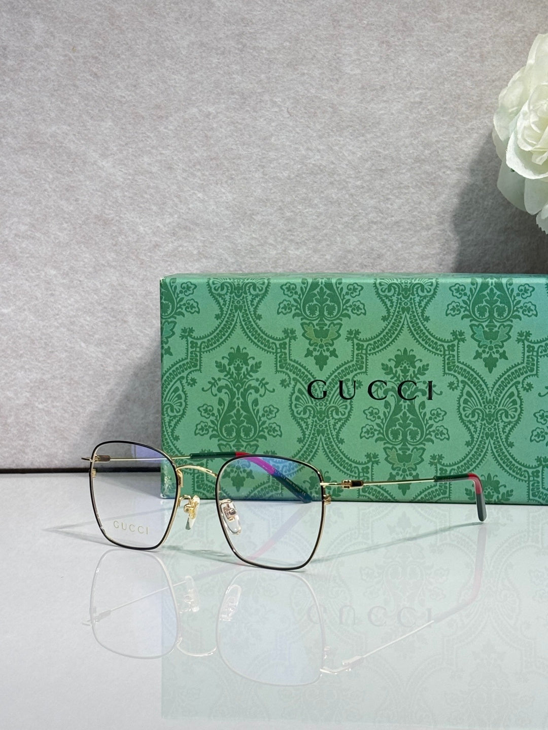 Gucci optical glasses with green rectangular frame and gold hinges, clear lenses