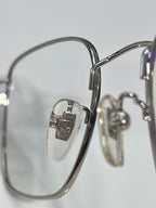 Gucci optical glasses closeup: silver frame, engraved hinge, clear lens