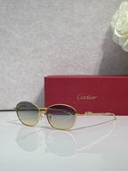 Gold-tone round glasses with smoky blue lenses and jeweled-look accents