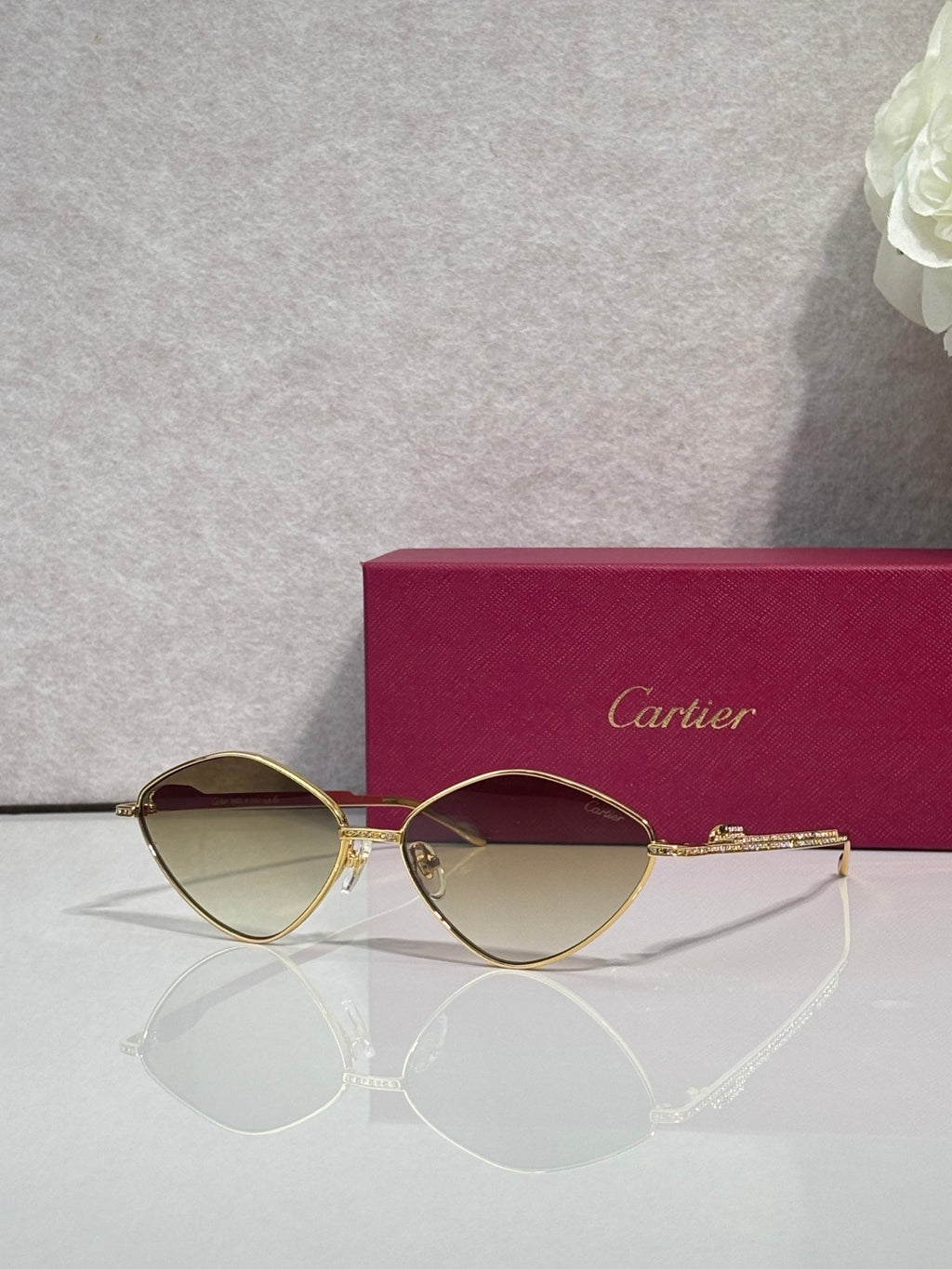 Gold-tone round sunglasses with dark lenses and rhinestone-accented arms