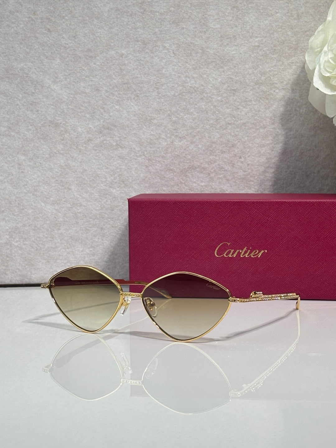 Gold-tone round sunglasses with dark lenses and rhinestone-accented arms