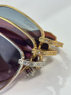 Gold-tone temple with rhinestone rows and tinted lens near the hinge