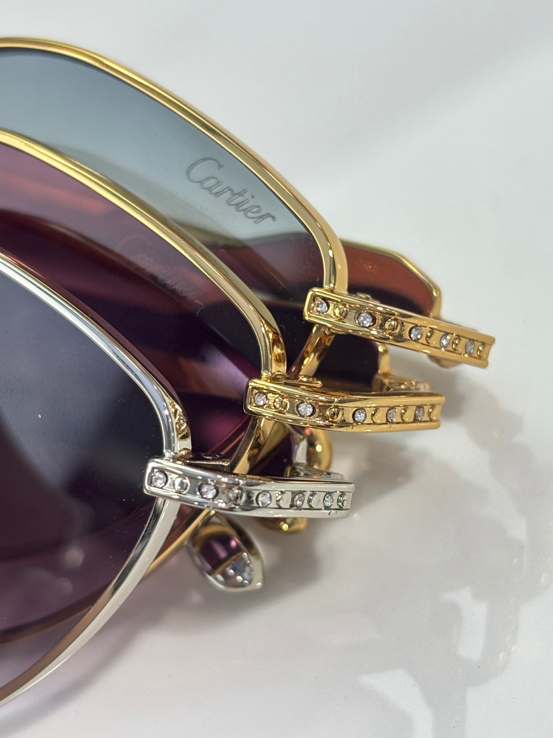 Gold-tone temple with rhinestone rows and tinted lens near the hinge