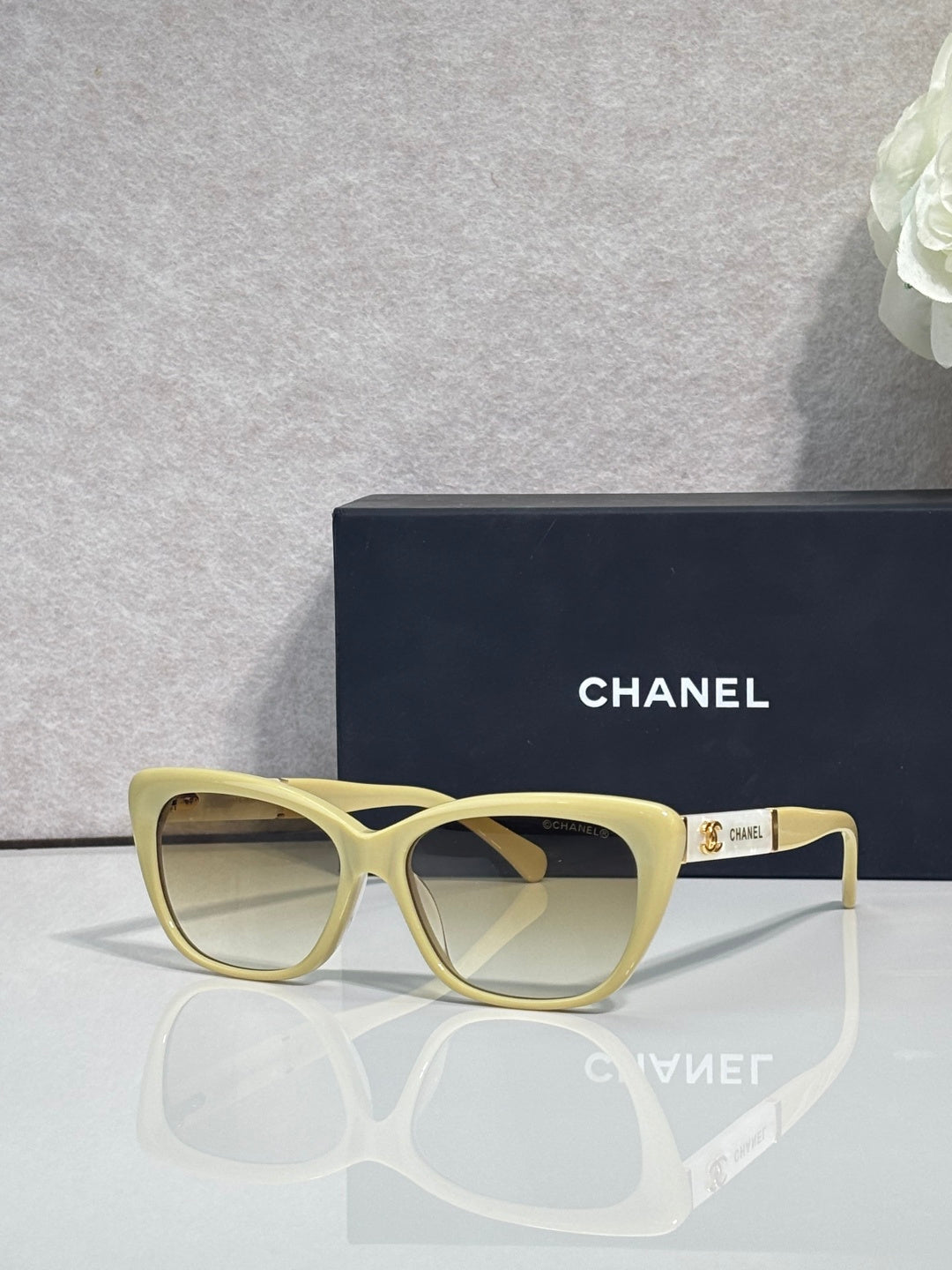 Chanel eyeglasses, light yellow square frames, clear lenses, gold logo on temple