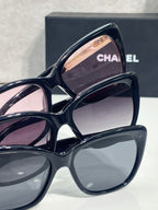 Chanel eyeglasses close-up, navy frames with pink lenses and gold logo hardware