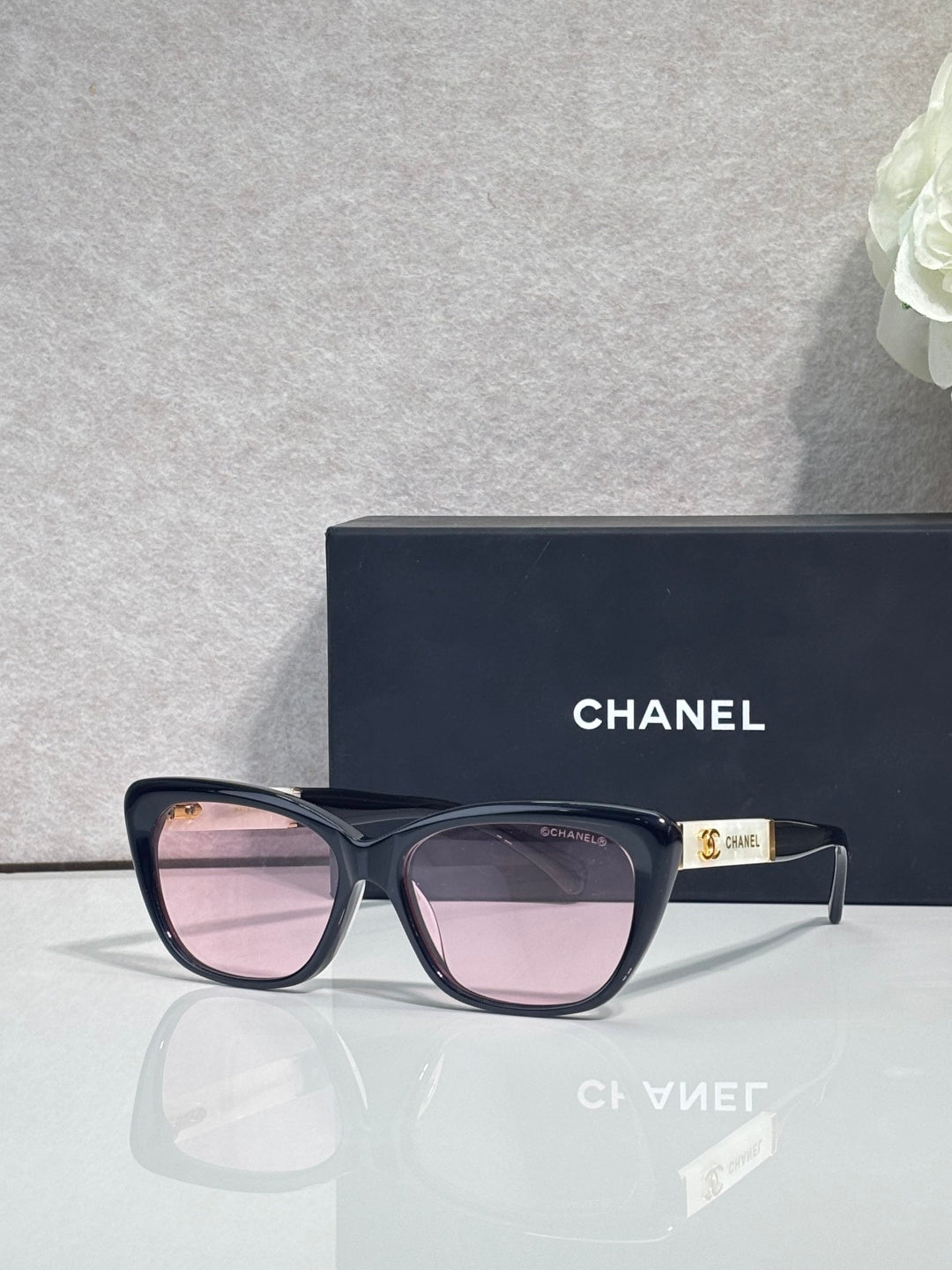 Chanel eyeglasses, black square frames, pink-tinted lenses, gold logo on temple