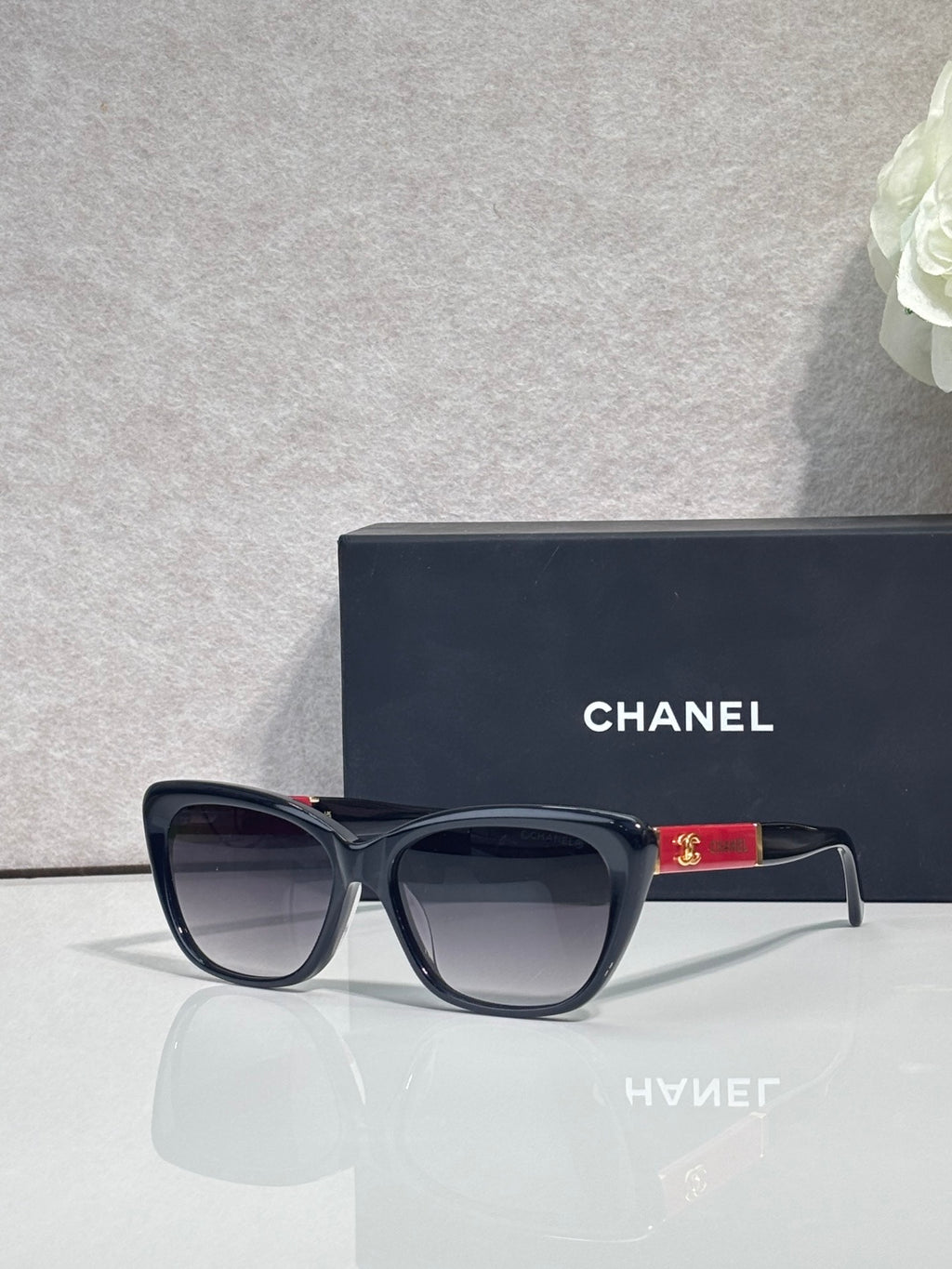 Chanel eyeglasses, black square frames, gray tinted lenses, gold logo on temple