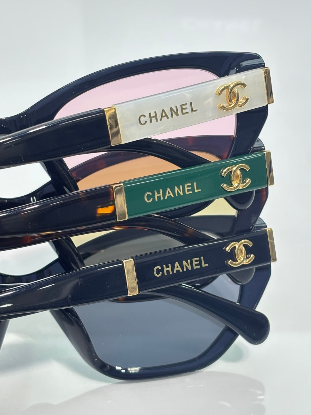 Chanel glasses close-up of temples: gold, green, and blue inlays with CHANEL text