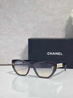 Chanel glasses with dark purple frames and tinted lenses, gold CC emblem on temple