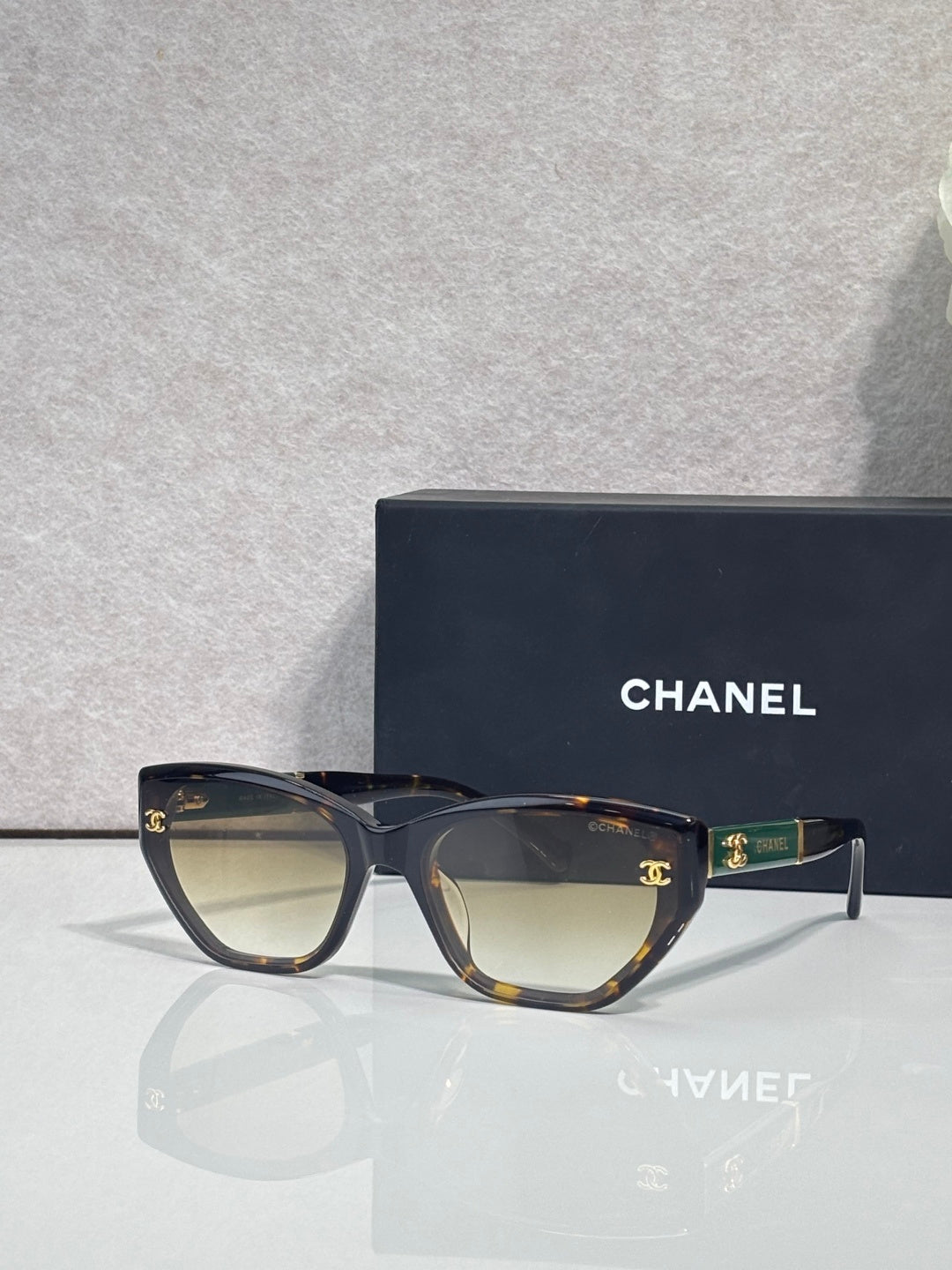 Chanel glasses with dark tortoiseshell frames and beige gradient lenses, gold CC accents