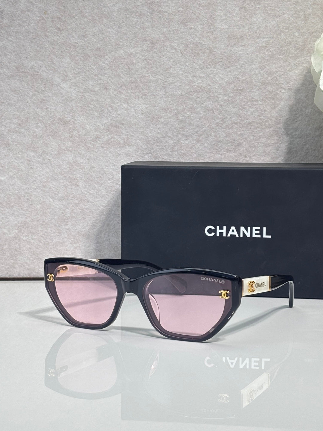 Chanel glasses with dark purple frames and pink gradient lenses, gold CC logo detail