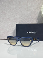 Chanel glasses with navy-blue frames and amber gradient lenses, gold CC details