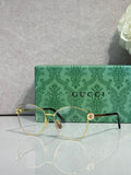 Gold-tone round eyeglasses with clear lenses and green patterned temples