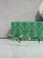 Gold-tone round eyeglasses with clear lenses and green patterned temples