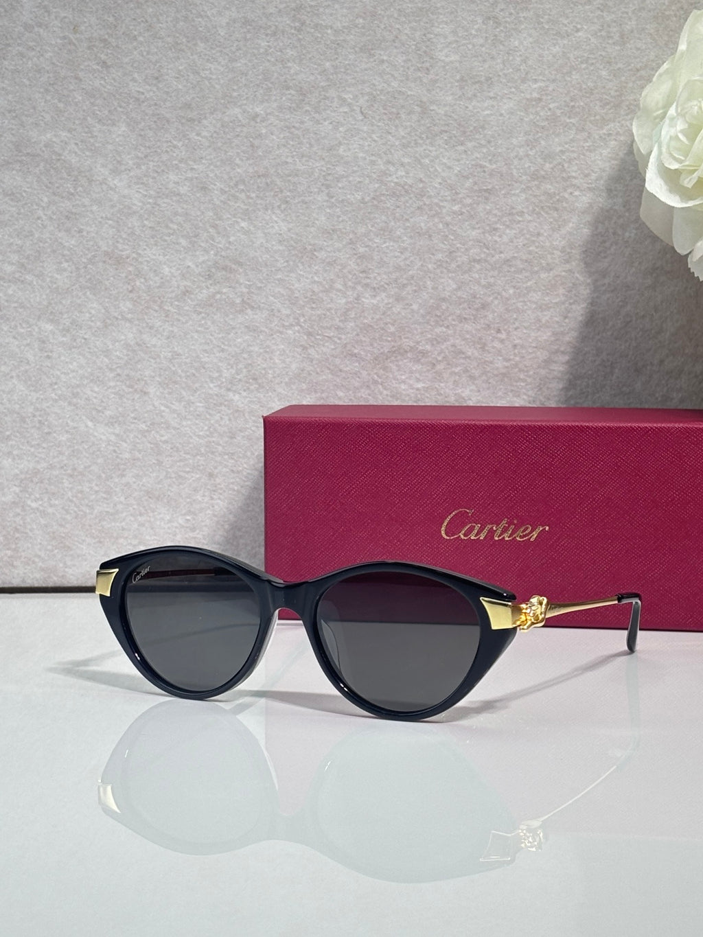 Cartier sunglasses with dark round frames, gold-tone bridge detail, and gradient tinted lenses