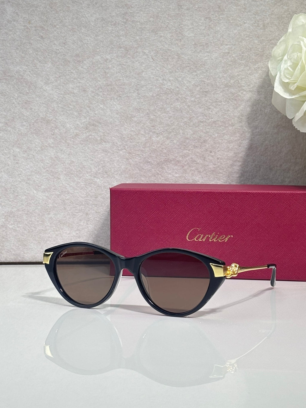 Cartier sunglasses with dark round frames, gold-tone hinges, and gradient tinted lenses