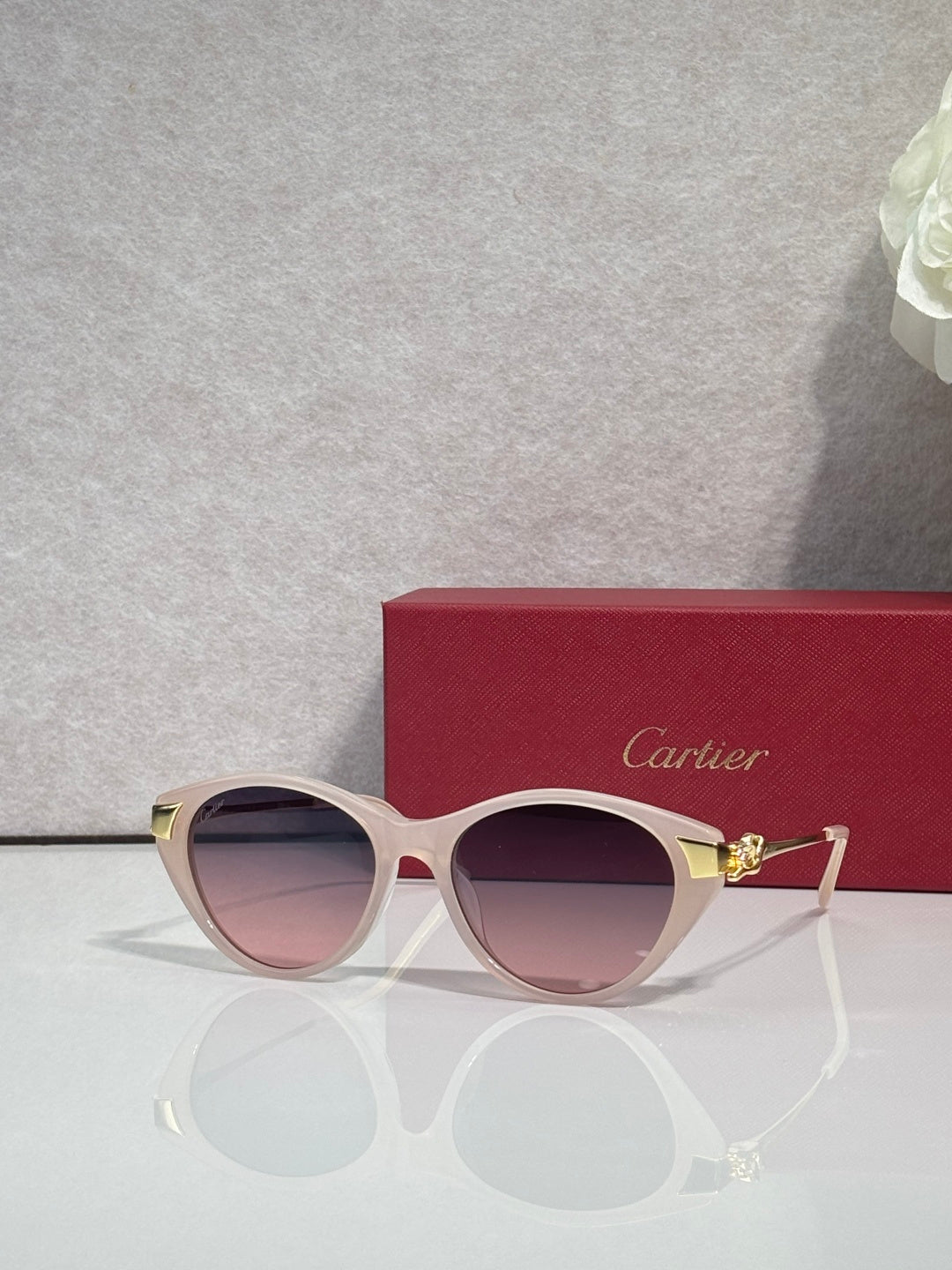 Cartier sunglasses with pale pink round frames, gold-tone accents, and tinted lenses
