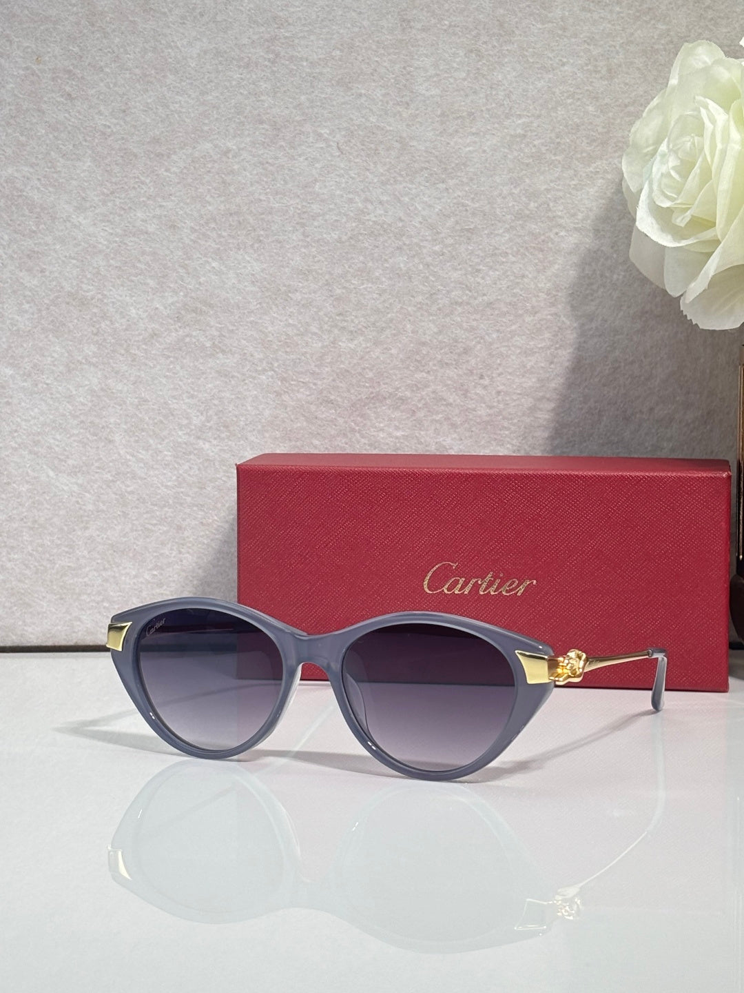 Cartier sunglasses with dark round frames, gold-tone accents, and light violet-tinted lenses