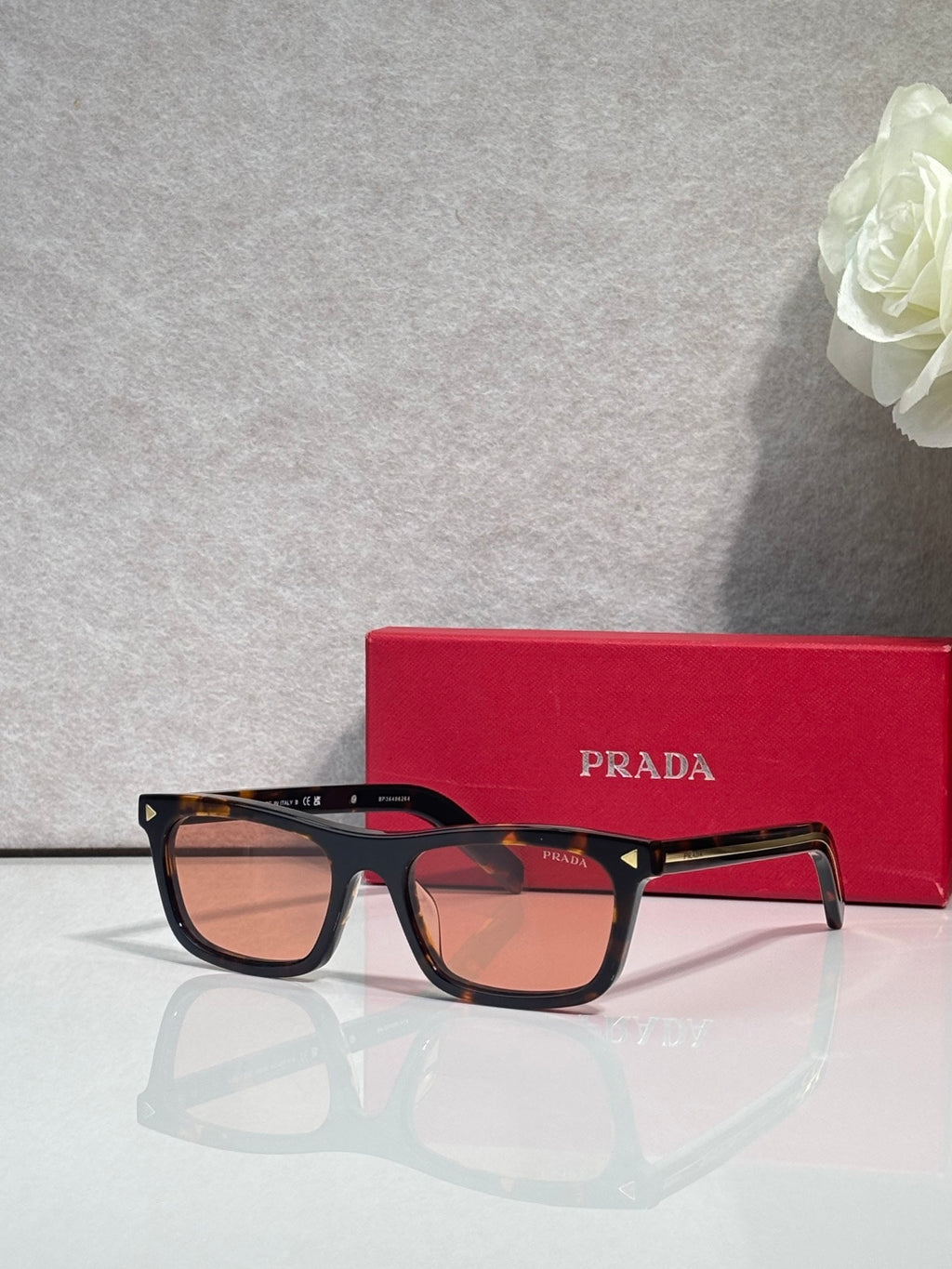 Prada sunglasses with dark frame and amber-tinted rectangular lenses