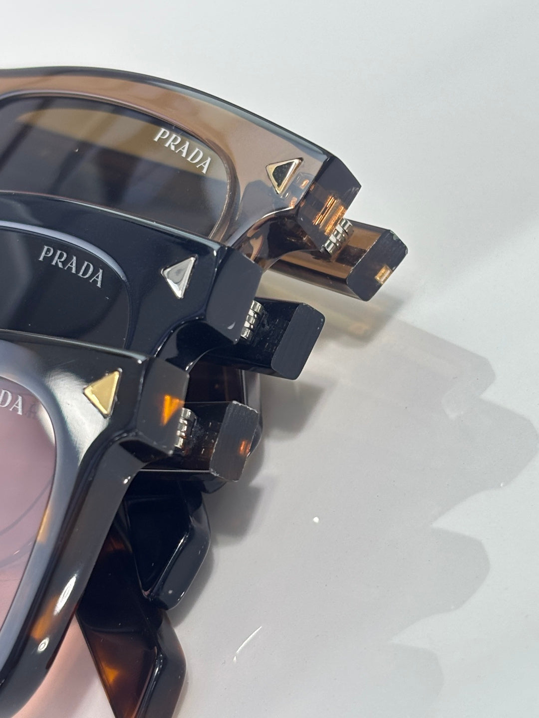 Prada sunglasses close-up with dark frames, gold accents, and logo detail
