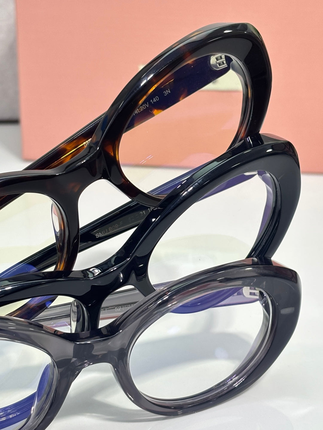 Miu Miu eyeglasses close-up: glossy dark frames, “miu miu” logo on arm