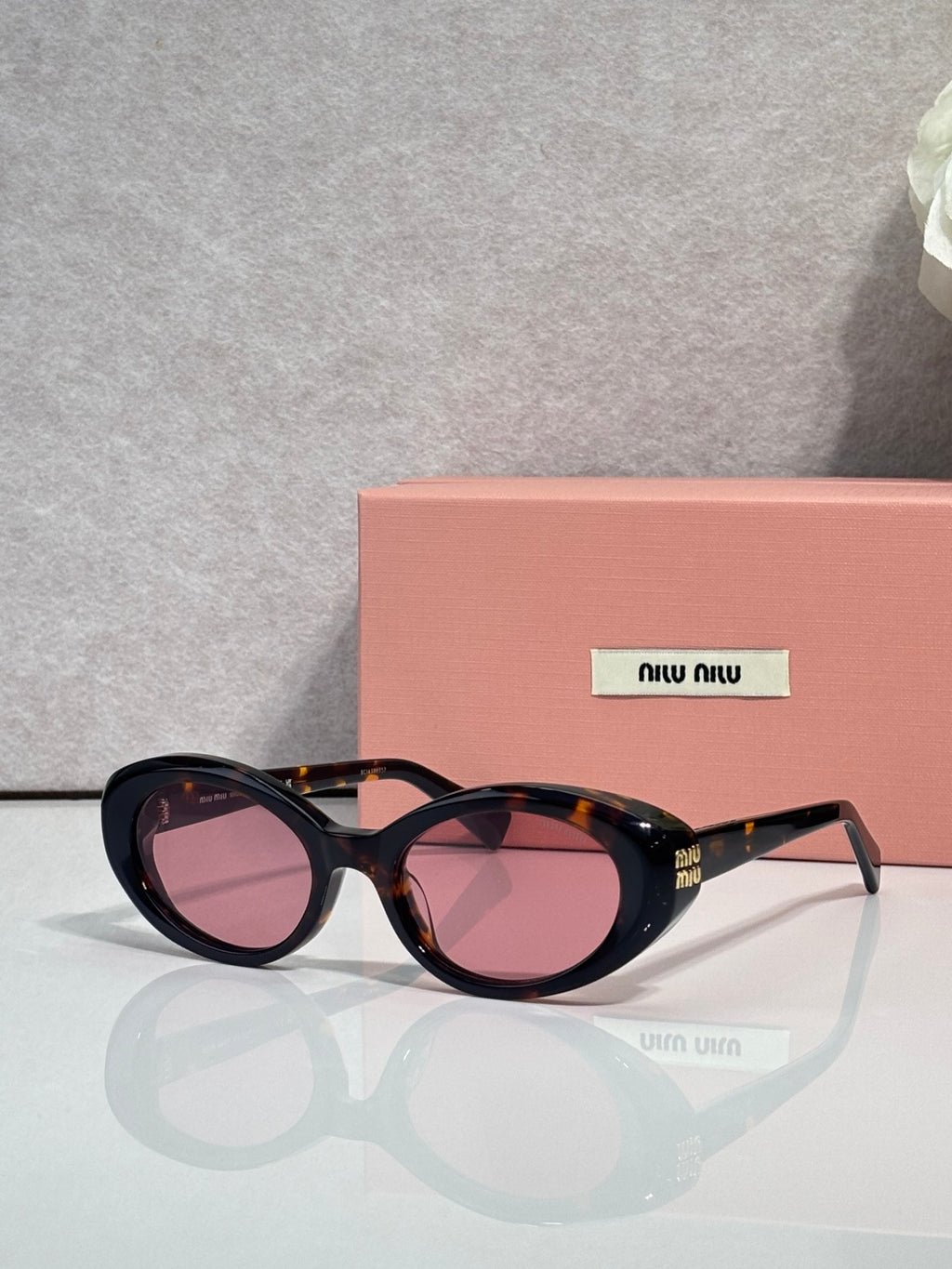 MiuMiu oval sunglasses with tortoise frames and pink-tinted lenses