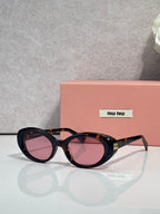 MiuMiu oval sunglasses with tortoise frames and pink-tinted lenses