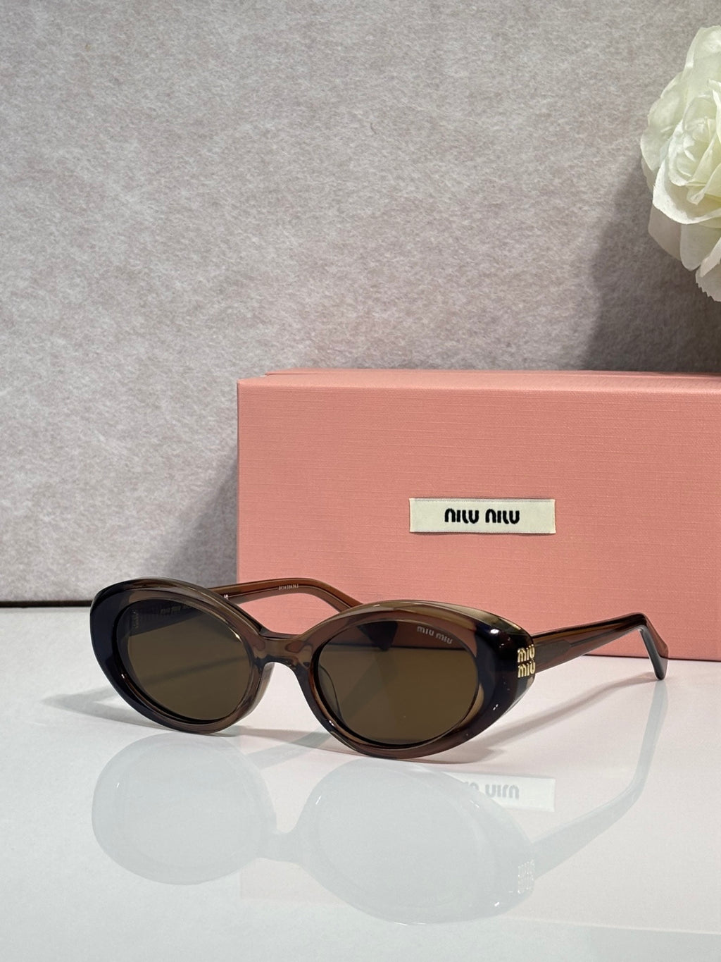 MiuMiu oval sunglasses with dark tortoise frames and dark tinted lenses