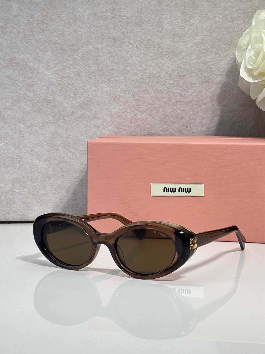 MiuMiu oval sunglasses with dark tortoise frames and dark tinted lenses