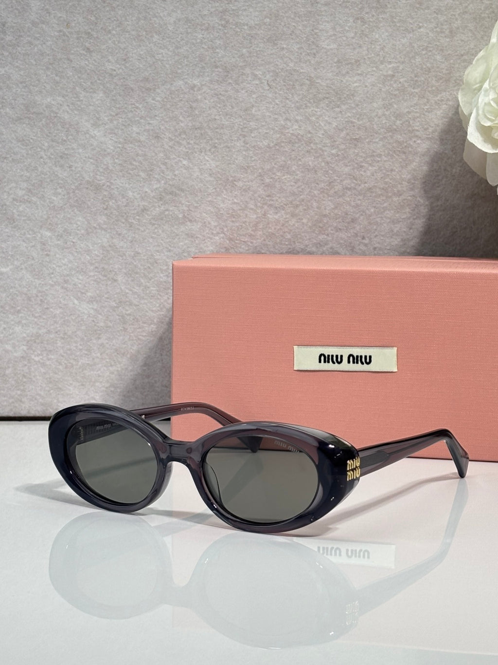 MiuMiu oval sunglasses with dark tortoise frames and black tinted lenses
