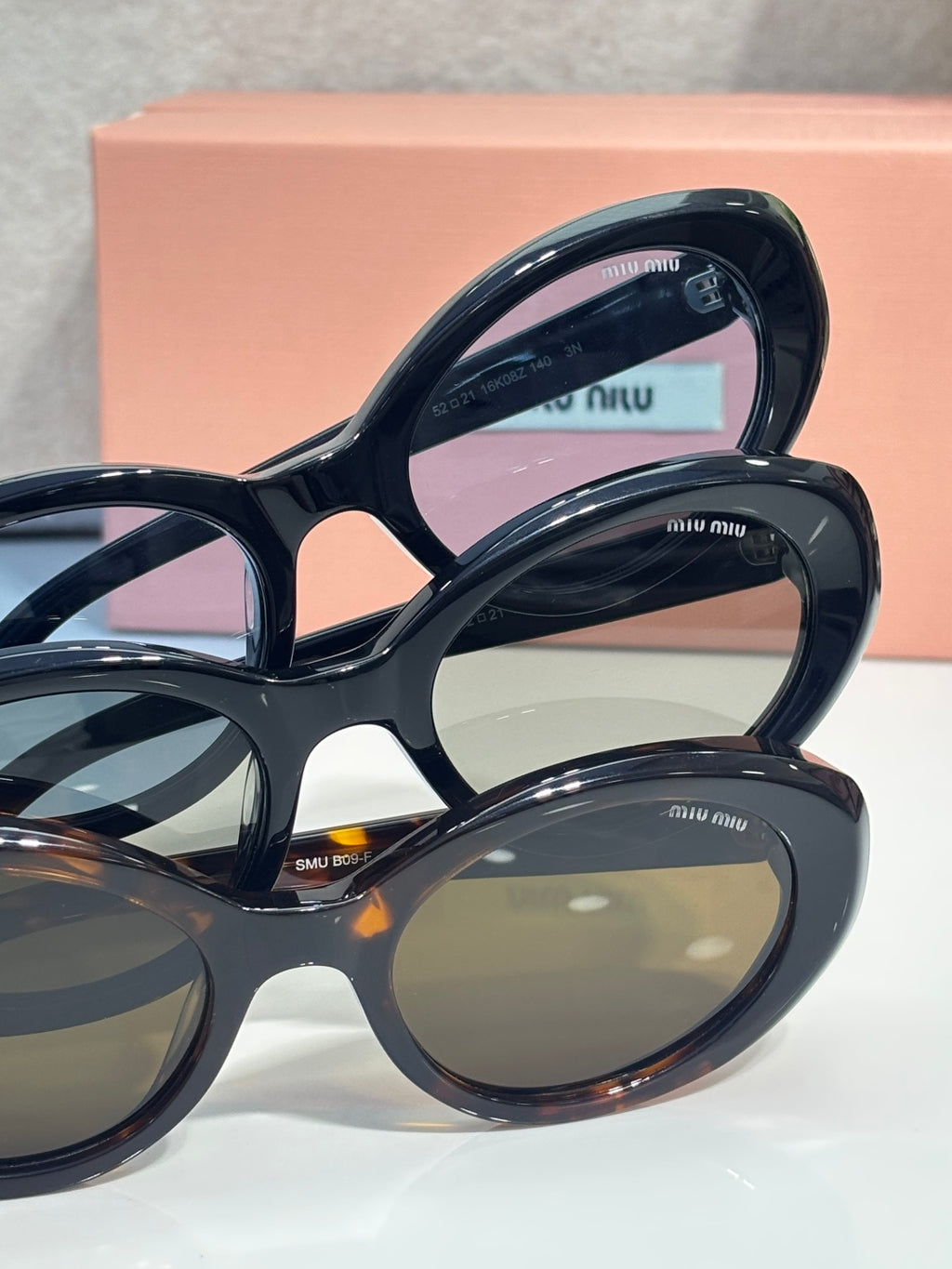 Miu Miu dark sunglasses pair with tinted lenses and Miu Miu logo temple tips