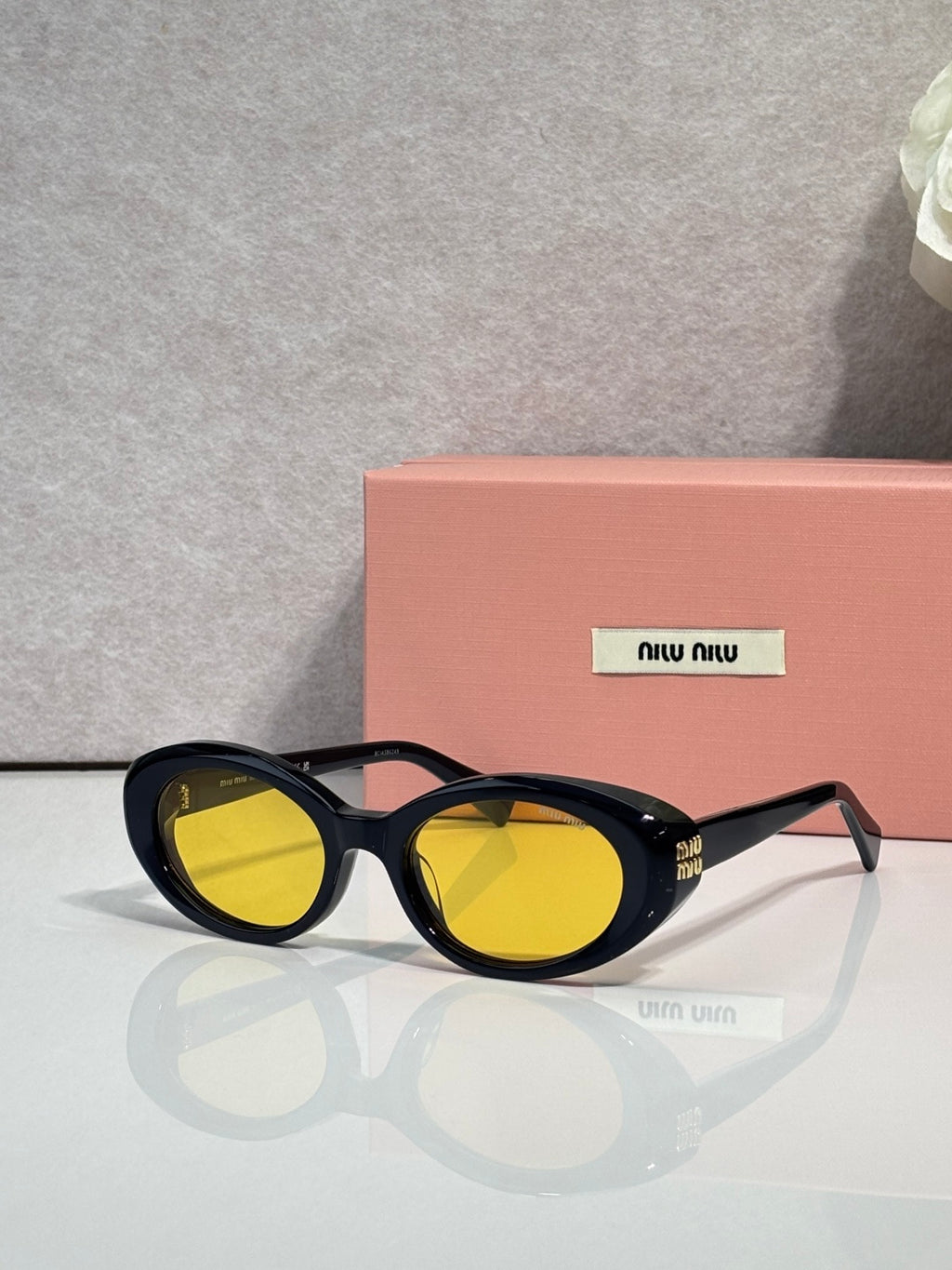 MiuMiu black round sunglasses with yellow lenses and slim metal logo detail