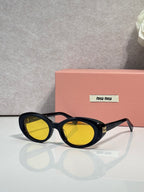 MiuMiu black round sunglasses with yellow lenses and slim metal logo detail