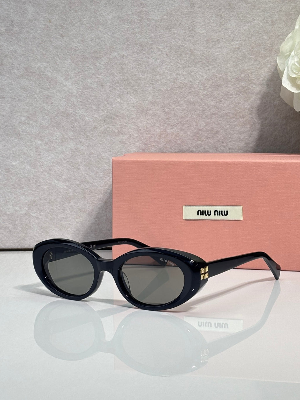 MiuMiu dark round sunglasses with yellow-tinted lenses and gold logo accents